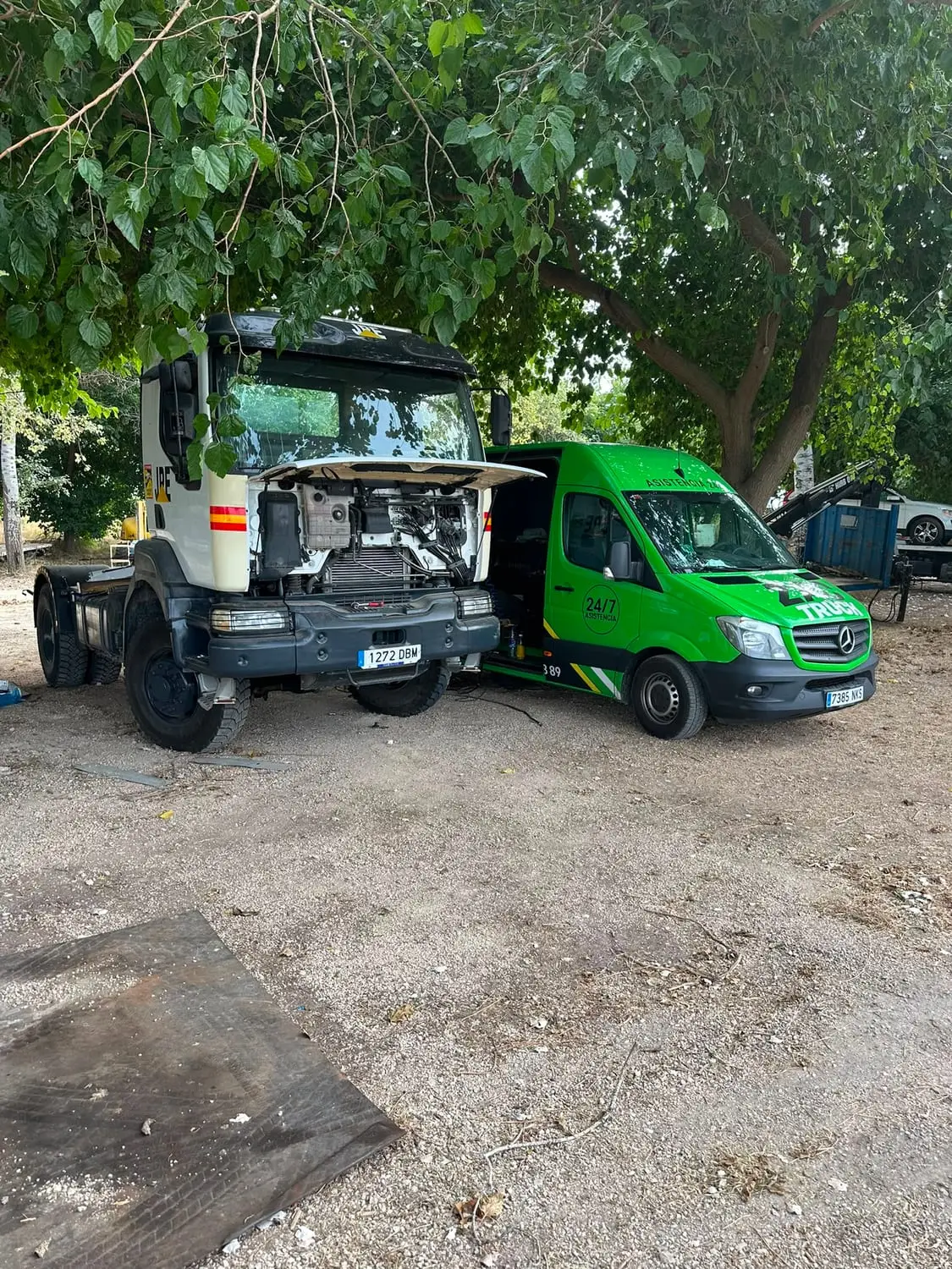 Furgoneta de ZAC TRUCK junto a un camión con la cabina basculada para acceder al motor