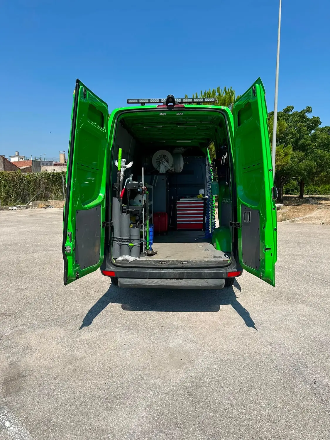 Inside the van through the rear doors: air hose reels, jacks, tool chest and tyre equipment