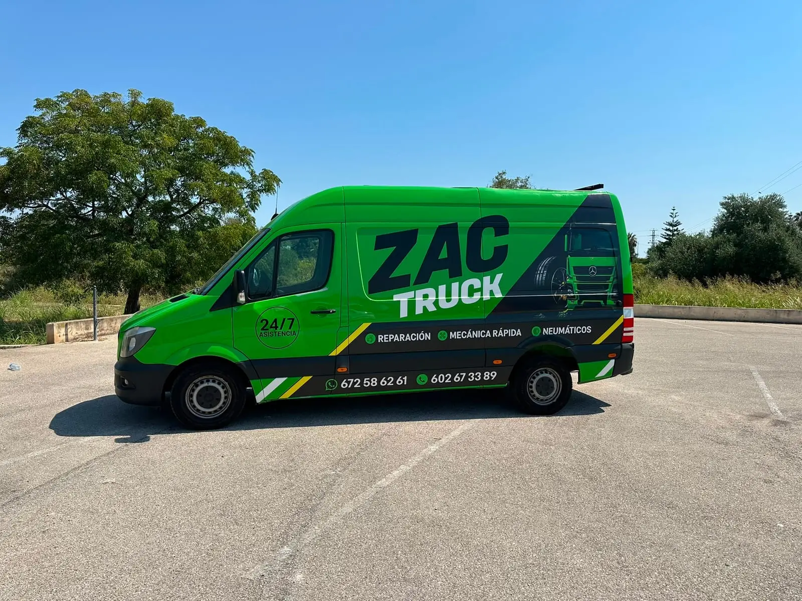 Lateral de la furgoneta taller de ZAC TRUCK con los servicios rotulados: reparación, mecánica rápida y neumáticos